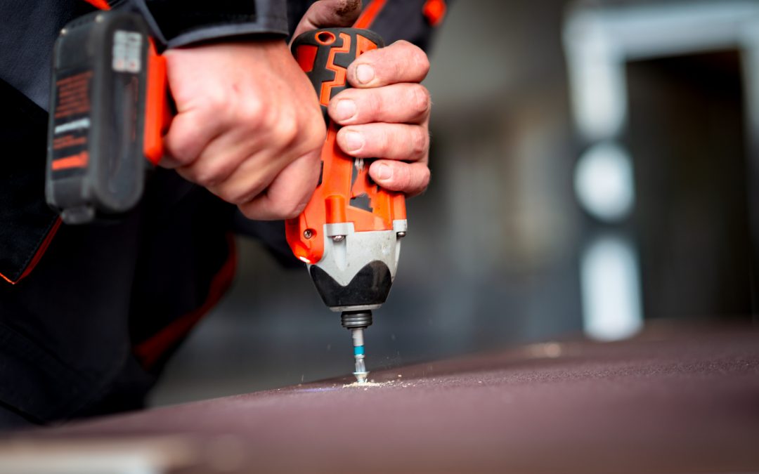 Hands of a general contractor holding a power drill